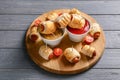 Board with delicious sausage rolls and sauces on wooden table Royalty Free Stock Photo