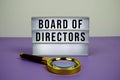 Board of Directors text on LED lightbox with magnifying glass on purple background Royalty Free Stock Photo