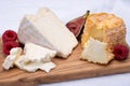 Board with french soft cheeses, Delice de Bourgogne French cow`s milk cheese from Burgundy region of France and yellow langres