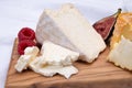 Board with french soft cheeses, Delice de Bourgogne French cow`s milk cheese from Burgundy region of France and yellow langres