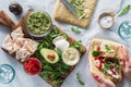 A board of fresh ingredients with hands preparing a turkey pesto wrap beside. Royalty Free Stock Photo