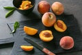 Board with fresh peaches on dark table