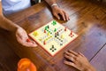 Board-game being played by a guy and a girl on a wooden table.