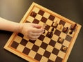 Board game of chess. Female hand holds wooden chess piece horse on a chessboard. Concept logic, strategy, winning
