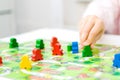 green people figure in hand of child. red, blue, green wood chips in children play - Board game and kids leisure concept