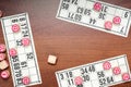 Board game lotto or bingo. Wooden lotto barrels with numbers and card on brown desk during a three-player game. Vintage
