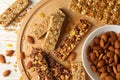 Board with granola bars and bowl with almond on wooden background, top view