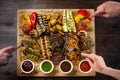 A board with grilled appetizers and sauces. Grilled vegetables and meat snack