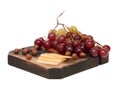 On the board, is layout of grapes, sliced cheese and a handful of hazelnuts. Isolated on white.