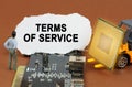 On the board with microcircuits lies a paper plate with the inscription - Terms Of Service Royalty Free Stock Photo