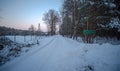 A board with the name of the town - Czarna Glina - in a forest area richly covered with snow.
