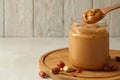 Board with peanut, spoon and jar with peanut butter on white table Royalty Free Stock Photo