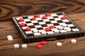 A board for playing checkers with chips on a wooden table, close-up, selective focus Royalty Free Stock Photo