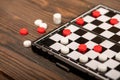 A board for playing checkers with chips on a wooden table, close-up, selective focus Royalty Free Stock Photo