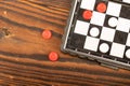 A board for playing checkers with chips on a wooden table, close-up, selective focus Royalty Free Stock Photo