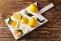 Board with ripe lemons, zest and fresh juice on wooden table Royalty Free Stock Photo