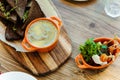 Board with rye crackers with rosemary, homemade liver pate and a plate with cheese, fresh cherry tomatoes and micro greens. Royalty Free Stock Photo