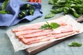Board with sliced raw bacon on blue wooden table Royalty Free Stock Photo