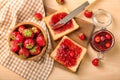 Board with slices of bread and delicious strawberry jam on light table Royalty Free Stock Photo