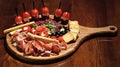 Board with snacks on wooden table. Snacks appetizing served on round board. Restaurant dish concept. Cold appetizers