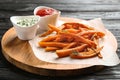 Board with sweet potato fries and sauces on wooden Royalty Free Stock Photo