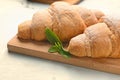 Board with tasty croissants on white table Royalty Free Stock Photo