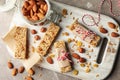 Board with tasty granola bars and nuts on background, top view