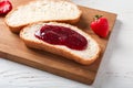 Board with toasts and strawberry jam on wooden table, closeup Royalty Free Stock Photo