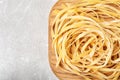 Board with uncooked egg noodles on grey table, top view Royalty Free Stock Photo
