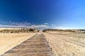 Board walk leads to a bright afternoon beach setting - Assateague, MD, USA