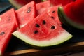 Board with watermelon slices on wooden table Royalty Free Stock Photo