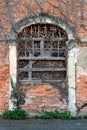 Boarded creepy looking old venetian style red brick abandoned suburban family house entrance covered with dried crawler plants Royalty Free Stock Photo