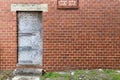 Boarded up door way abandoned red brick back alley warehouse Royalty Free Stock Photo