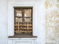 Boarded up window with broken glass on weathered plaster wall Royalty Free Stock Photo