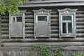 Boarded up windows on the old wooden wall of the house. Carving adorns the old window. The walls of the house from the Royalty Free Stock Photo