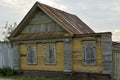 Boarded up windows on the old wooden wall of the house. Carving adorns the old window. The walls of the house from the old logs