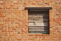 Boarded up with wooden planks window opening in an old red brick wall Royalty Free Stock Photo