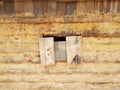 Boarded window on old log and mud cabin Royalty Free Stock Photo