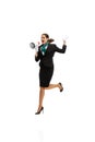 Portrait of beautiful young woman, flight attendant jumping with megaphone isolated on white studio background. Royalty Free Stock Photo