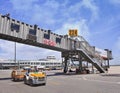 Boarding bridge with tow tractor on foreground on Beijing Capital International Airport.