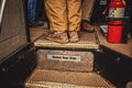 Boarding a bus - men\'s feet at top of steps reading Watch Your Step and including bus drivers feet and fire extinguisher Royalty Free Stock Photo