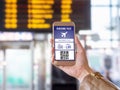 Boarding pass in mobile phone. Woman holding smartphone in airport with modern ticket on screen.