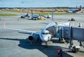 Boarding passengers on a plane using a jet bridge at Sheremetyevo airport, Moscow, in the background a runway under construction Royalty Free Stock Photo