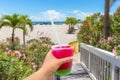 Boardwalk on beach in St. Pete with Hand holding a glass with cocktail and straw, Florida, USA Royalty Free Stock Photo