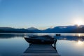 Boardwalk and boats with lake scenery and mountains in the background Royalty Free Stock Photo