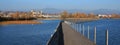 Boardwalk leading to Rapperswil. Blue lake Obersee and golden tr