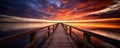 Boardwalk pier bay dock over a flaming orange and red sunset sky.