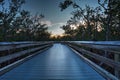 Boardwalk through the swamp, leading to Pass at sunset i Royalty Free Stock Photo