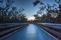 Boardwalk through the swamp, leading to Pass at sunset i Royalty Free Stock Photo