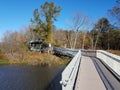 Boardwalk trail with fence and wood tower or lookout with water